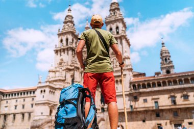 Santiago 'daki Camino de Santiago haccının sonu olarak Santiago de Compostela' nın ana meydanı olan Obradeiro Meydanı 'nda duran genç bir gezgin..