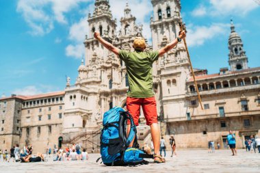 Santiago 'daki Camino de Santiago hac yolculuğunun sonu olarak Santiago de Compostela' nın ana meydanı olan Obradeiro Meydanı 'nda (plaza) duran genç bir gezgin..