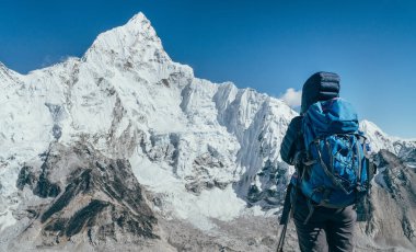 Yürüyüşte fren yapan genç gezgin bayan Khumbu Buzulu 'nun tadını çıkarıyor. Gorakshep, Nepal yakınlarındaki Everest Ana Kampı rotasında. Arka planda Nuptse 7861 metre. Etkin tatil kavramı