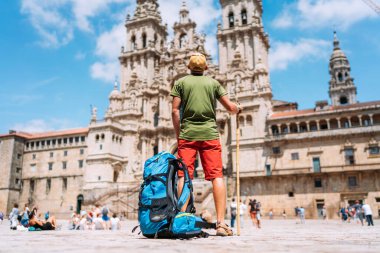 Santiago 'daki Camino de Santiago haccının sonu olarak Santiago de Compostela' nın ana meydanı olan Obradeiro Meydanı 'nda duran genç bir gezgin..