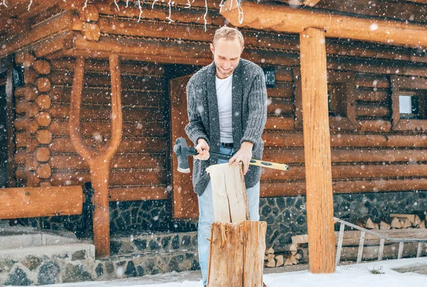 人们在雪地的院子里砍柴 找一个有厚厚的雪片背景的房子生火 冬季乡村假日的概念形象 — 图库照片