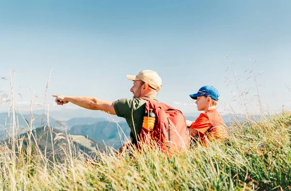 Father Showing Something Interesting His Teenager Son Sitting Grass Mounting — Stock Photo, Image