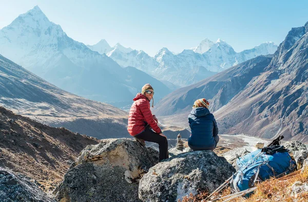 可爱的情侣们在位于杜赫拉4620米附近的珠穆朗玛峰大本营远足路线上休息 背包客们离开背包和远足的杆子 与Ama Dablam山顶一起欣赏山谷美景 — 图库照片