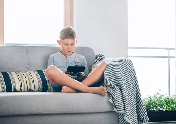 Niño Preadolescente Sentado Casa Sofá Acogedor Utilizando Gamepad Con Teléfono —  Fotos de Stock
