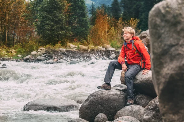 Young Man Tourist Sits Rocky Mountain River Bank — Stock Photo, Image