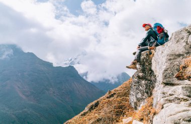 Uçurumun kenarında oturan ve yüksek irtifada Everest Ana Kampı 'nda (EBC) Phortse, Nepal yakınlarındaki yürüyüş rotasında Imja Khola Vadisi' nin tadını çıkaran genç bir gezgin kadın. Etkin tatil konsepti resmi.
