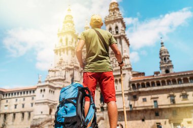 Santiago 'daki Camino de Santiago haccının sonu olarak Santiago de Compostela' nın ana meydanı olan Obradeiro Meydanı 'nda duran genç bir seyyah..