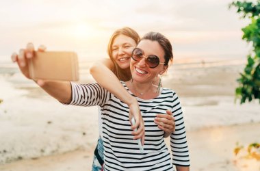 İki beyaz kız arkadaş Samui Adası 'ndaki Tayland Körfezi' nde akıllı telefon kullanarak selfie çekiyorlar. Dikkatsiz tatil konsepti resmi.