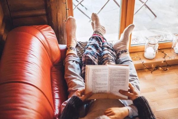 暖かい田舎の家の居心地の良いソファの上に一緒に横たわる父と息子の読書本 子供たちへの読書トップビューのコンセプトイメージ — ストック写真
