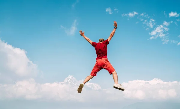 Szczęśliwy Człowiek Ubrany Czerwono Skacząc Chmurach Góry Annapurna Zakres Tle — Zdjęcie stockowe