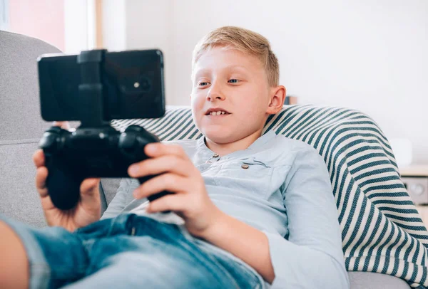 Preteen Chlapec Sedí Doma Útulné Pohovce Používá Gamepad Chytrým Telefonem — Stock fotografie