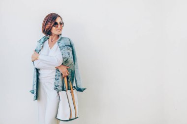 Büyük beden kot ceketli şık giyinmiş bir kadın. Şehir modası