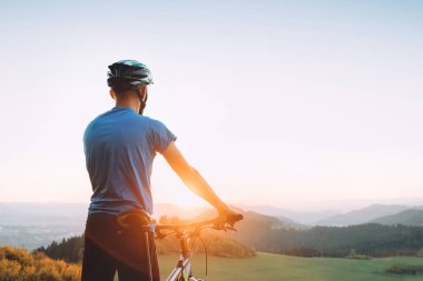 Erkek motorcu dağda gün batımıyla karşılaşır