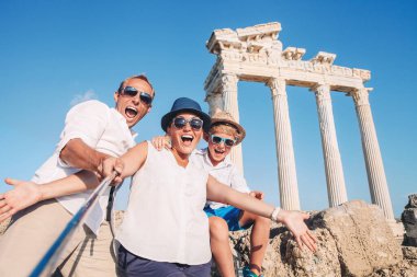 Antika köşe yazısının arka planında çılgın mutlu aile fotoğrafı var. Apollo Tapınağı, Side, Türkiye