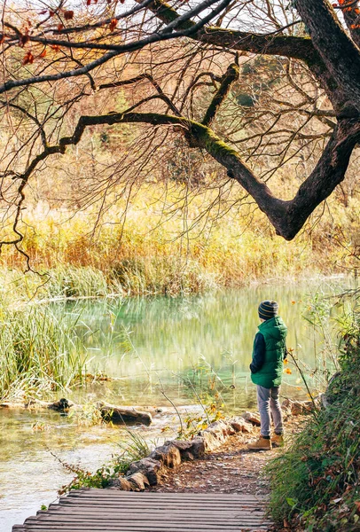 少年は秋の公園の池の近くに滞在し 最後の晴れた秋の日 — ストック写真