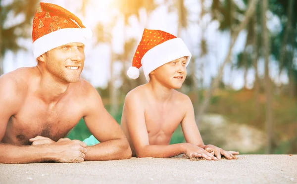 热带Bisland海滩上父亲和儿子头戴Sants帽的画像 — 图库照片