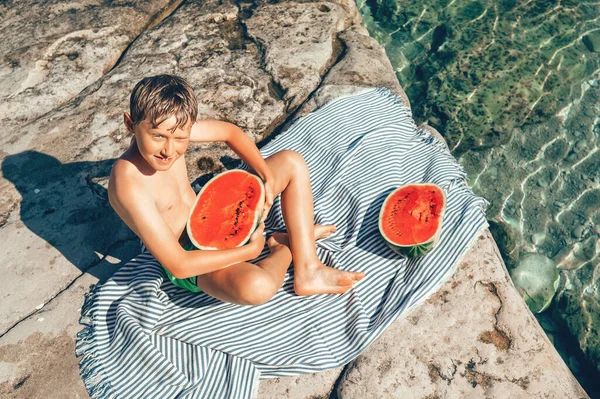 夏のレジャー 少年は海で泳ぐ後に大きなスイカを食べる準備ができて — ストック写真