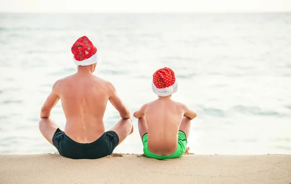 Πατέρας Και Γιος Σάντα Καπέλα Κάθονται Στην Παραλία Του Ωκεανού — Φωτογραφία Αρχείου