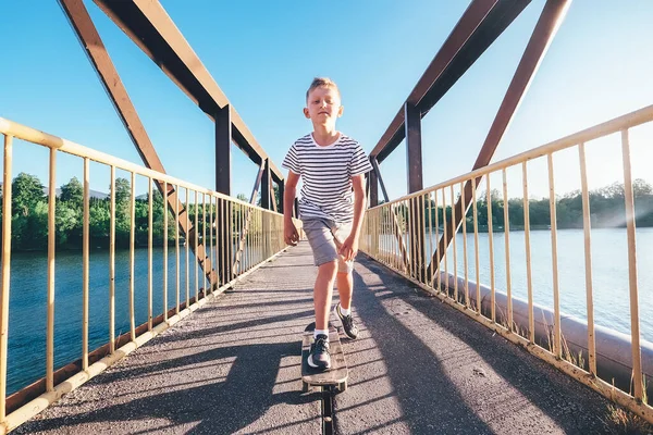 Kluk Bruslí Skateboardu Mostě Přes Řeku — Stock fotografie