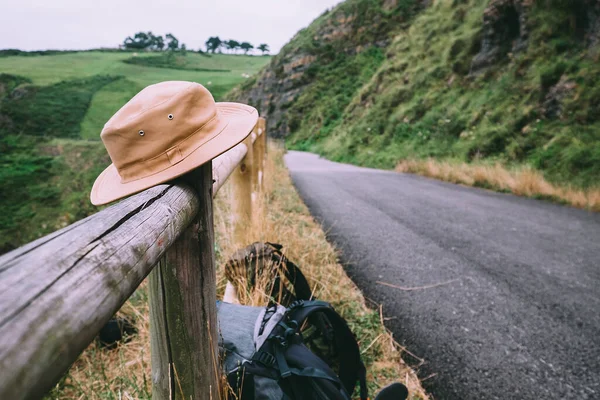 Turist Şapkası Yeşil Tepelerdeki Boş Yol Boyunca Çitin Üzerinde — Stok fotoğraf