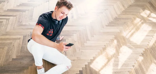 Ung Man Använder Sin Smartphone Med Hörlurar Lyssna Musik Och — Stockfoto