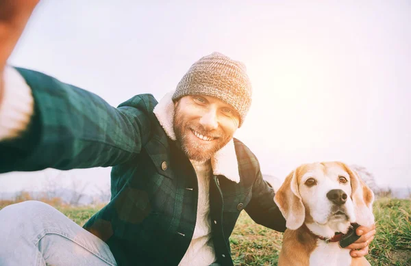 陽気で笑顔の男は 散歩中に親友のビーグル犬と一緒に自撮り写真を撮ります 人間とペットのコンセプトイメージ — ストック写真