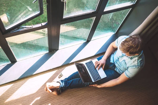 Man Werkt Met Laptop Zittend Vloer Bij Het Open Raam — Stockfoto