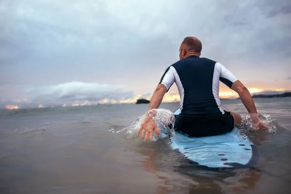 Surfer Κάθεται Στην Σανίδα Του Σερφ Για Κύματα Στο Ηλιοβασίλεμα — Φωτογραφία Αρχείου