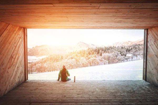 Uomo Siede Hangar Legno Con Vista Sulla Valle Innevata — Foto Stock