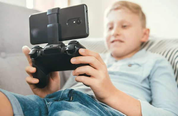 Preteen Menino Usar Gamepad Com Smartphone Joga Jogos Deitado Sofá — Fotografia de Stock