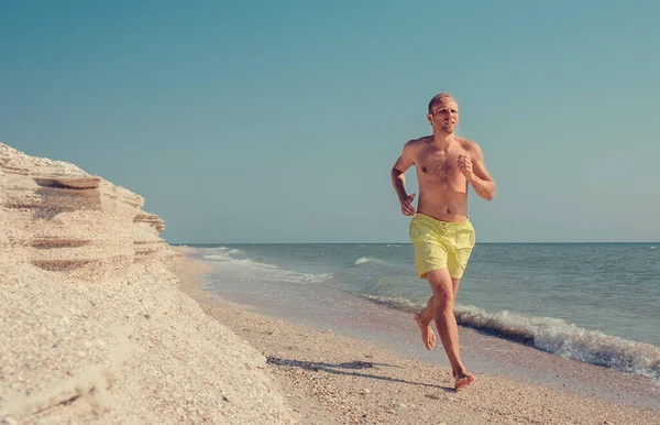 男は裸足で海の波線を走る — ストック写真