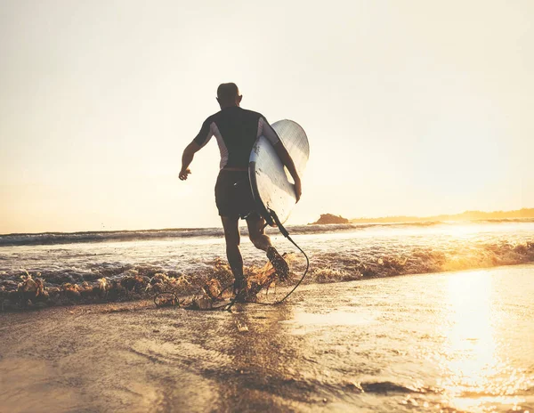 Surfer Σανίδα Του Σερφ Τρέχει Κύματα Του Ωκεανού Ώρα Ηλιοβασιλέματος — Φωτογραφία Αρχείου