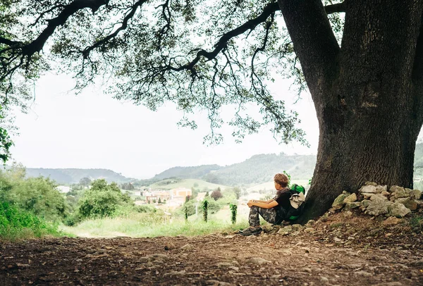 小背包客在乡间大树下休息 — 图库照片