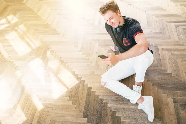 Young Man Using His Smartphone Headphones Listen Music Sit Floor — Stock Photo, Image