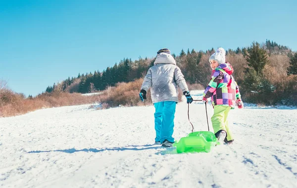 小さな男の子と女の子はそりを運び 冬のそりの時間を楽しむ — ストック写真