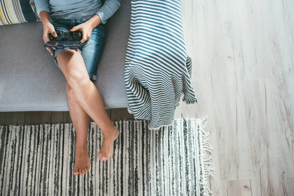 Junge Sitzt Auf Sofa Und Spielt Mit Smartphone Und Gamepad — Stockfoto