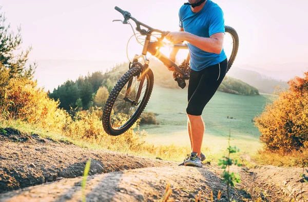 サイクルクロス競争メンバー男マウンテンバイクを運ぶ彼のバイクで丘の上に — ストック写真