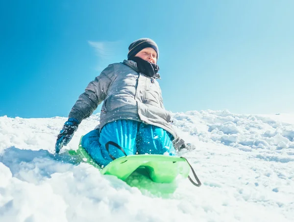 Glücklicher Junge Rutscht Mit Dem Schlitten Vom Schneehügel Herunter Outdoor — Stockfoto
