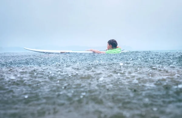 小男孩的第一步冲浪者试图在热带雨中站在船上 — 图库照片