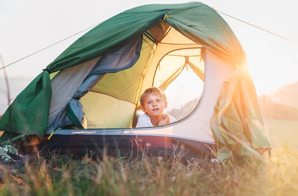 少年はテントの中で休む 自然の中で日没の時間 — ストック写真