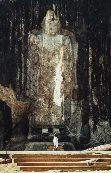 Tiny woman figurine stands at the foot of oldest Buddha idol in Sri Lanka