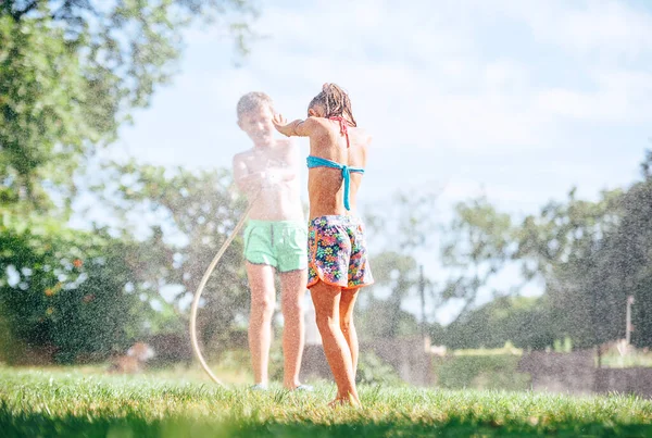 Dvě Děti Bratr Sestra Hrát Zavlažovací Hadicí Letní Zahradě — Stock fotografie