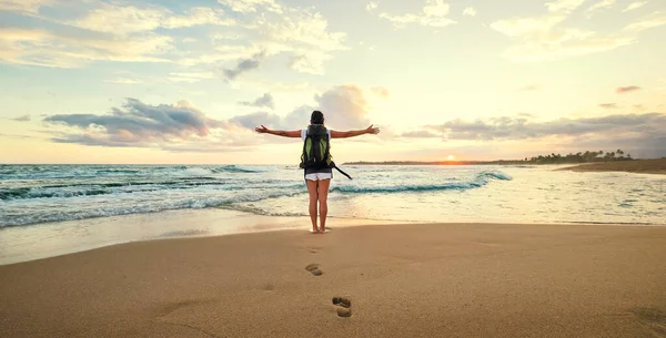 Γυναίκα Backpacker Χαιρετισμό Ένα Ηλιοβασίλεμα Στην Ακτή Του Ωκεανού — Φωτογραφία Αρχείου