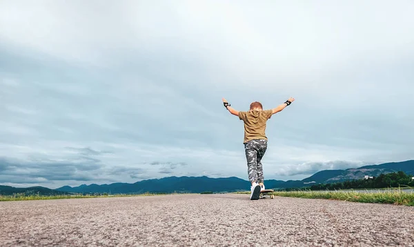 男孩在路上的滑板上滑冰 — 图库照片