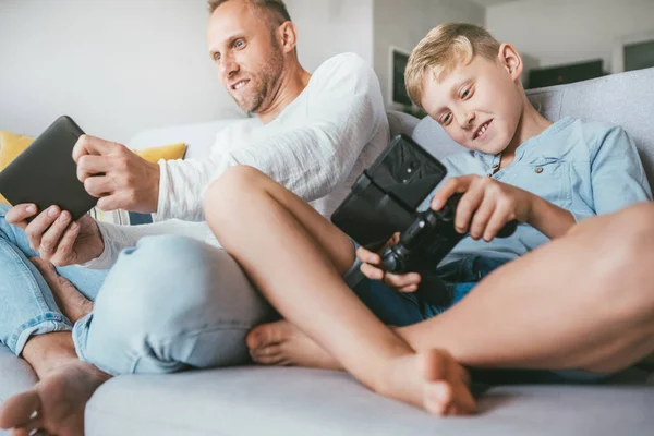 Apa Fia Érzelmileg Játszik Elektronikus Eszközök Tabletta Gamepad Nappaliban — Stock Fotó