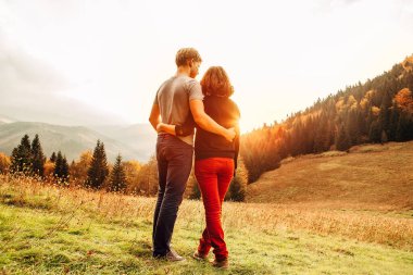 Birbirine aşık çiftler, gün batımındaki çayırlarda büyük eşekler gibi.