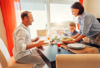 Anne aç ailesine sofraya bir tabak yemek getirir.