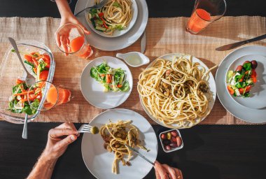 Greyfurt suyu, makarna ve salatalı aile yemeği.