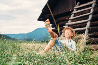 Oğlan yaz öğleden sonra samanlığın altında uyuyor.