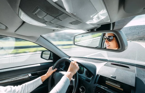Bir Kadın Dikiz Aynasına Yansıyan Bir Araba Kullanır — Stok fotoğraf